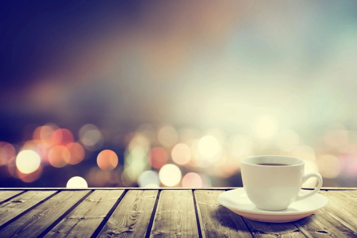 Coffee cup on wooden table with bokeh background.