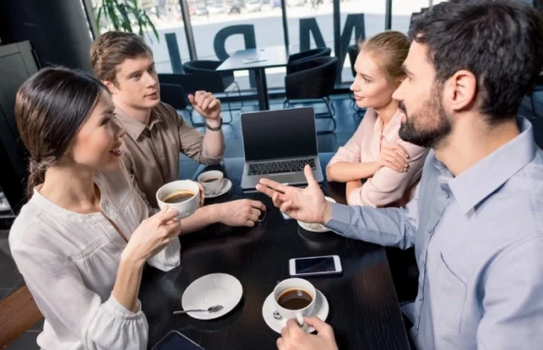 Friends having coffee and conversation at cafe.