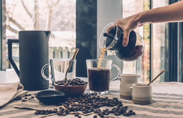 Pouring coffee into a glass mug.